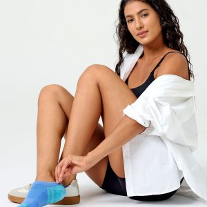 A detailed close-up product photograph of Closemate's light blue ribbed cotton no-show invisible boat socks, set against a smooth, neutral beige background. The image clearly highlights the breathable fabric texture, the precise contoured fit around the foot, and the intricate patterned weave on the footbed designed for comfort.